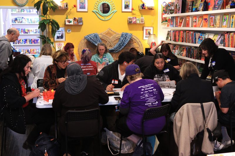 Workshop participants at a table carving linoleum blocks and printing