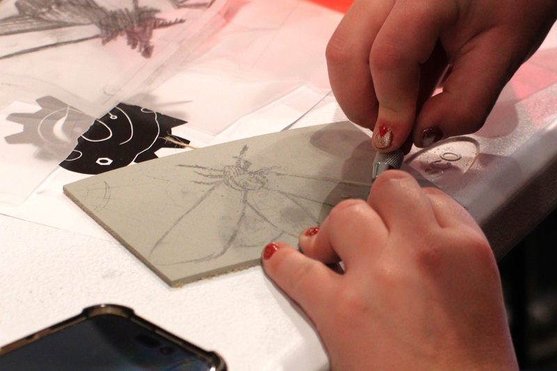 Close-up of hands carving a linoleum block