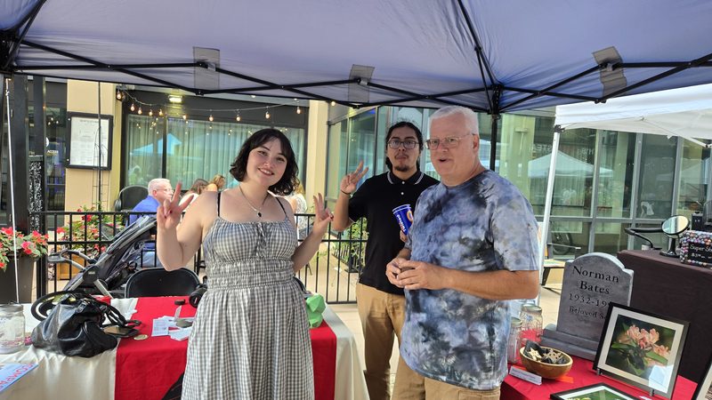 Volunteers at an outdoor booth at a downtown street event